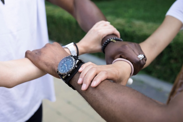 Free photo close up diverse friends holding arms