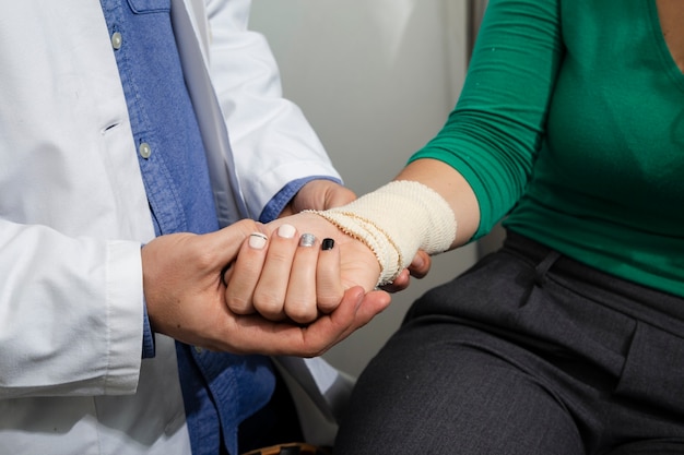 Foto gratuita chiuda sul medico che controlla il braccio bendato