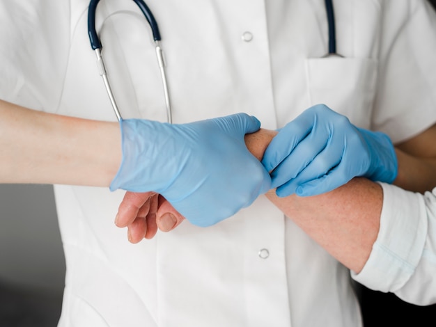 Close-up doctor checking wrist