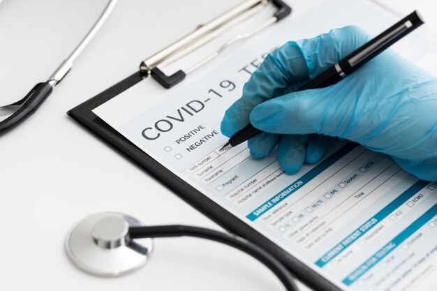 Close-up doctor completing covid medical form