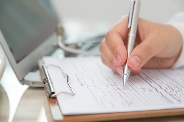 Close-up of doctor filling out a prescription