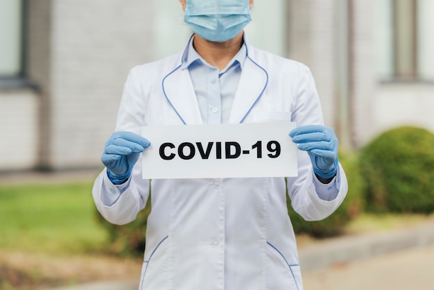 Close-up doctor holding covid sign