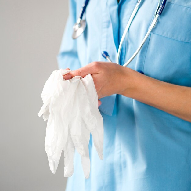 Close-up doctor holding gloves