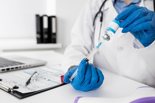 Free photo close-up doctor holding medical syringe