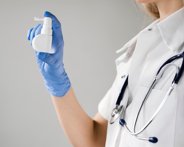 Close-up doctor holding mouth spray