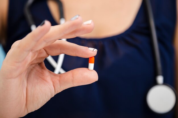 Close-up doctor holding a pill