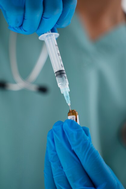 Close up doctor holding syringe and vial