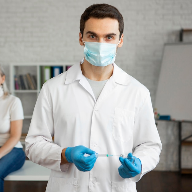 Close-up doctor holding syringe