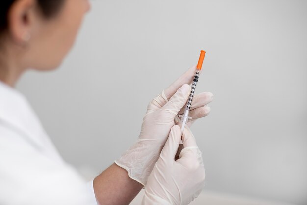 Close up doctor holding syringe