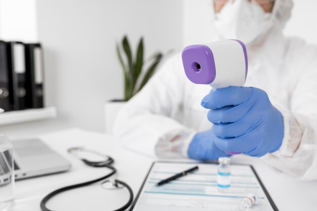 Close-up doctor holding thermometer