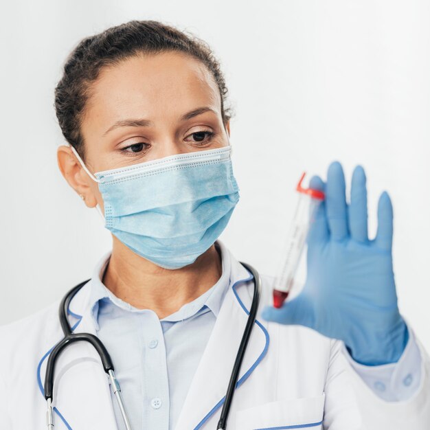 Close-up doctor holding vial