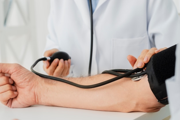 Close-up doctor inflating blood pressure cuff