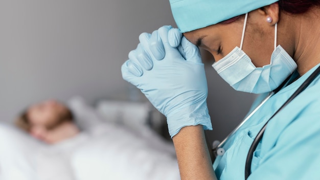 Close up doctor praying for patient