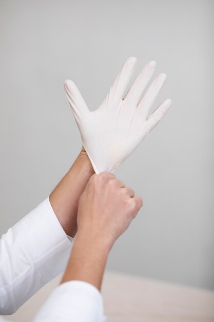 Close up doctor putting on glove