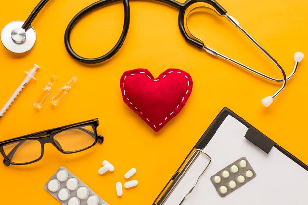 Close-up of doctor's desk with eyeglasses over yellow table