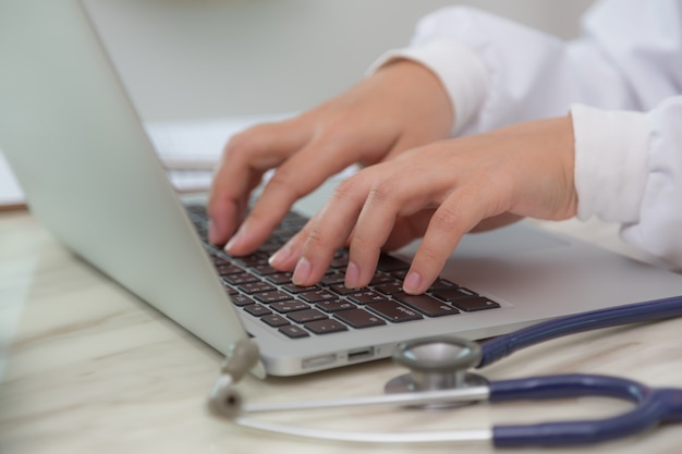 Free photo close-up of doctor's hands typing