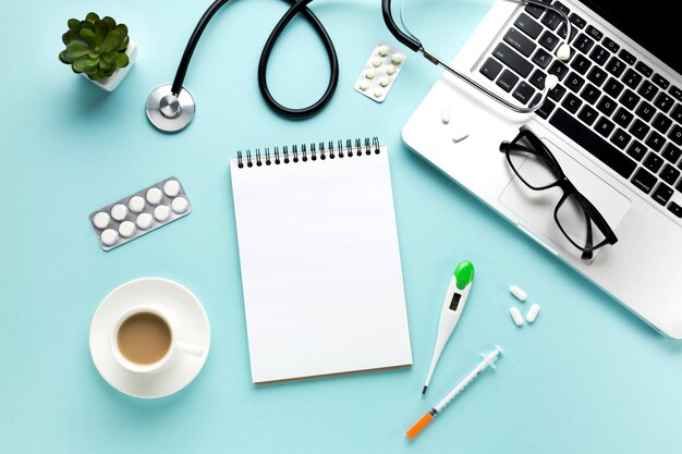 Close-up of doctor table with medical items and cup of coffee