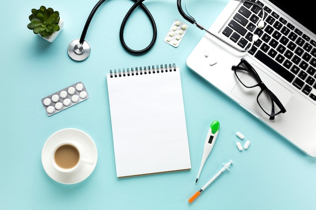 Close-up of doctor table with medical items and cup of coffee