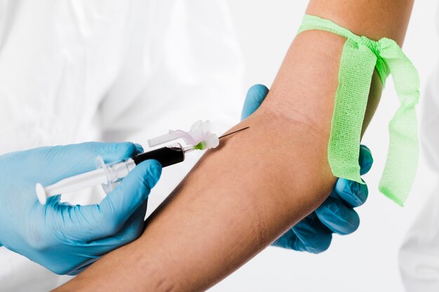 Close-up doctor taking blood sample from sick person