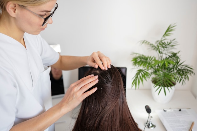 Free photo close up doctor treating dandruff at clinic