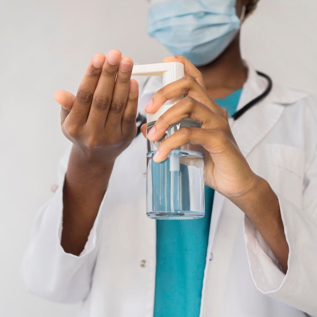 Close-up doctor using disinfectant