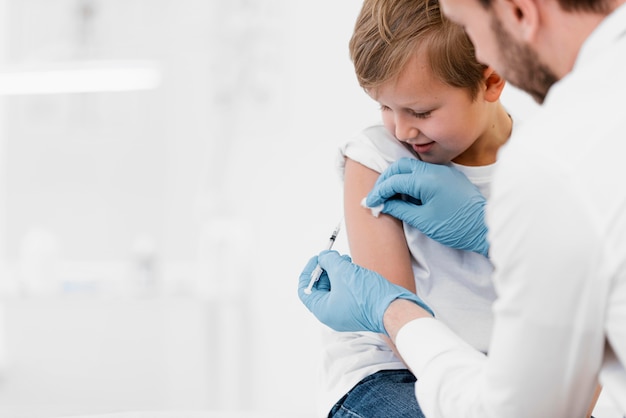 Close-up doctor vaccinating kid