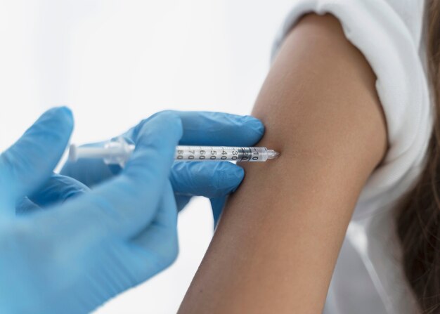 Close-up of doctor vaccinating a little girl