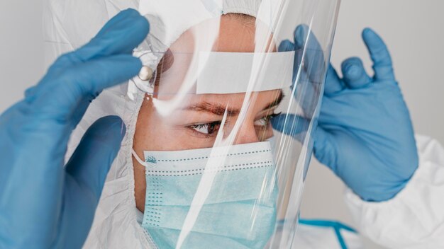 Close-up doctor wearing protective wear