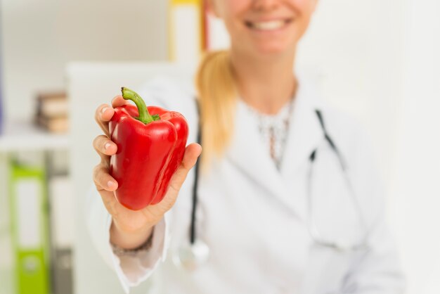 Close-up doctor with red bell pepper