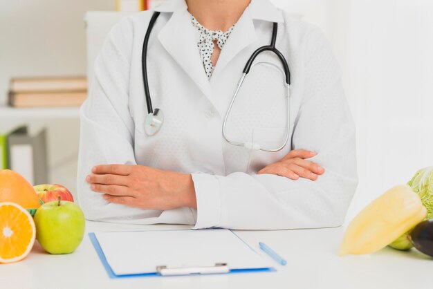 Close-up doctor with stethoscope and fruits