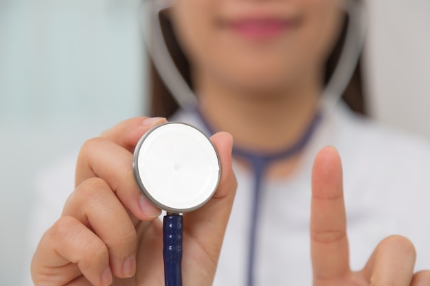 Close-up of doctor with stethoscope and showing her index finger