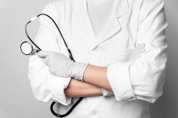 Close-up doctor with stethoscope and surgical gloves