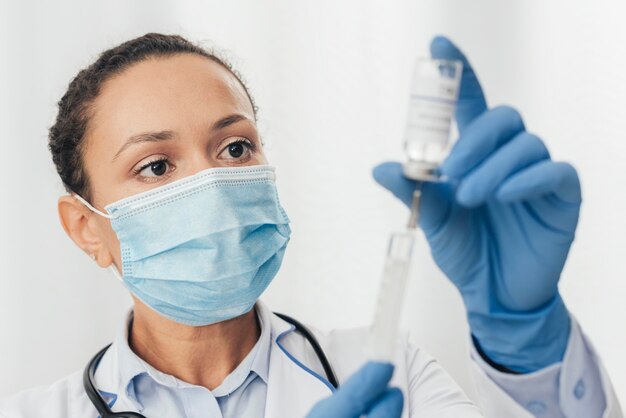 Close-up doctor with syringe and serum