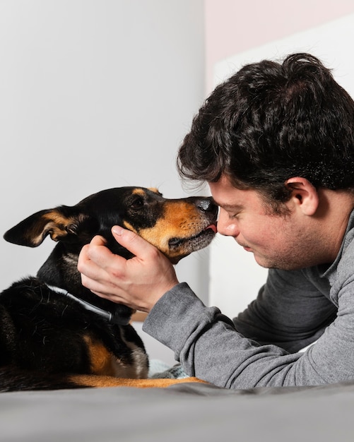 Foto gratuita chiuda sul cane che lecca l'uomo sul viso