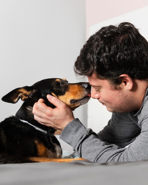 Free photo close up dog licking man on face