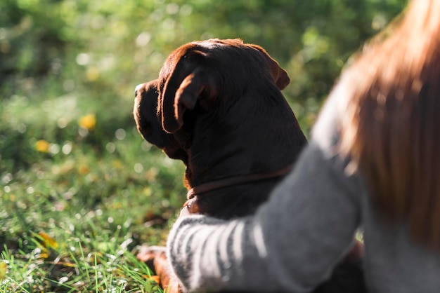 Close-up of dog with his pet owner at park