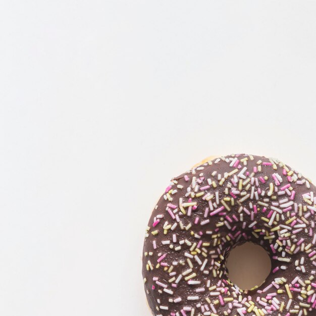 Close-up of donut with sprinkles on white background