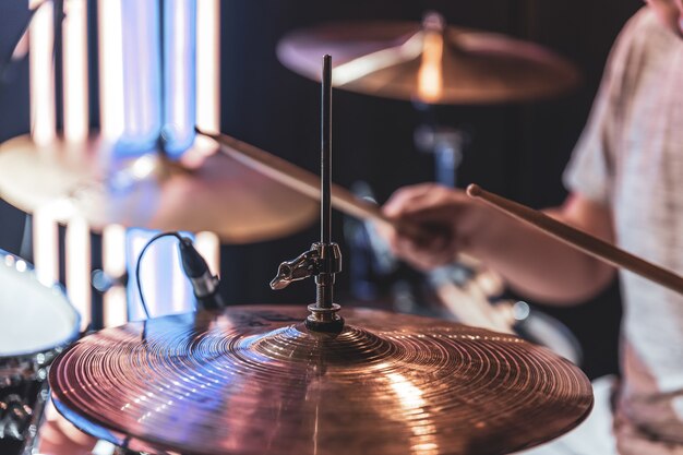 Close-up of a drum cymbal on a blurred background as the drummer plays.