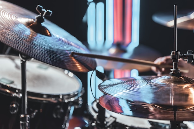 Close-up of drum cymbals as the drummer plays with beautiful lighting on a blurred background.