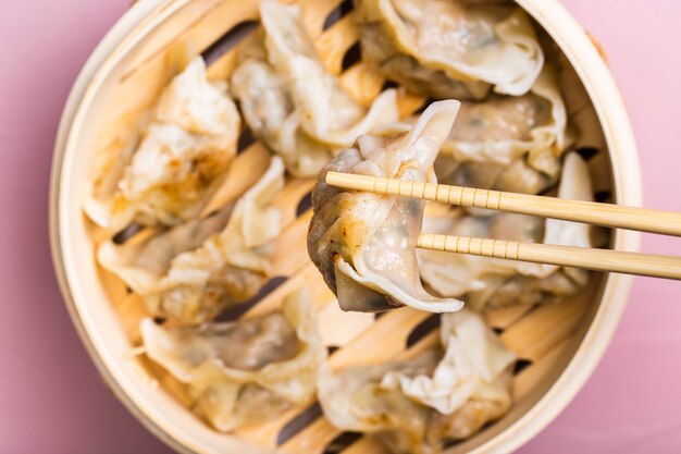 Close-up dumpling in chopsticks