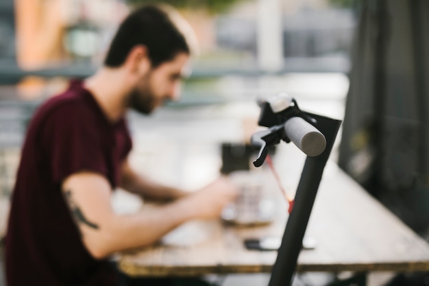 Close up e-scooter handle with defocused man