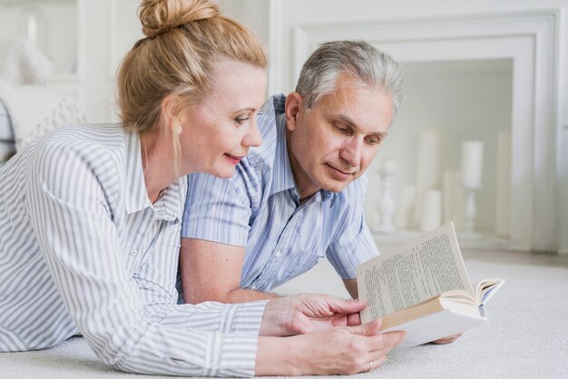 Close-up elderly couple reading a book