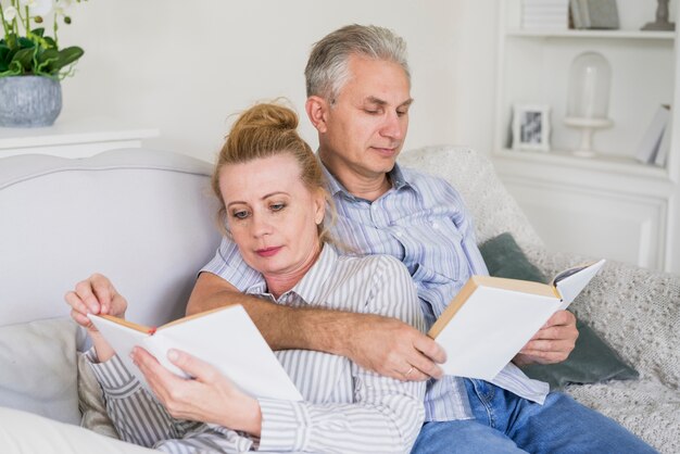 Close-up elderly man and woman reading together