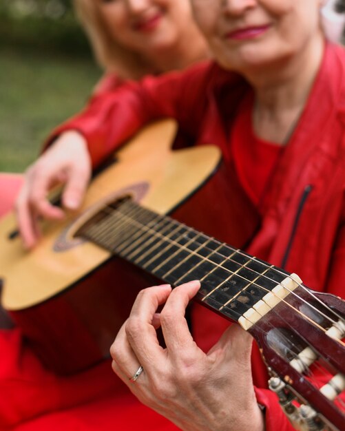 ギターを弾くクローズアップ高齢女性
