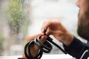 Free photo close-up of electrician's hand holding black electric cable