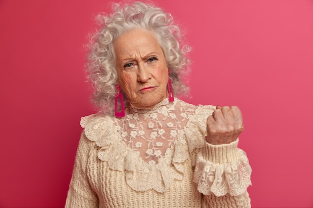 Close up on elegant elderly woman wearing stylish clothes isolated