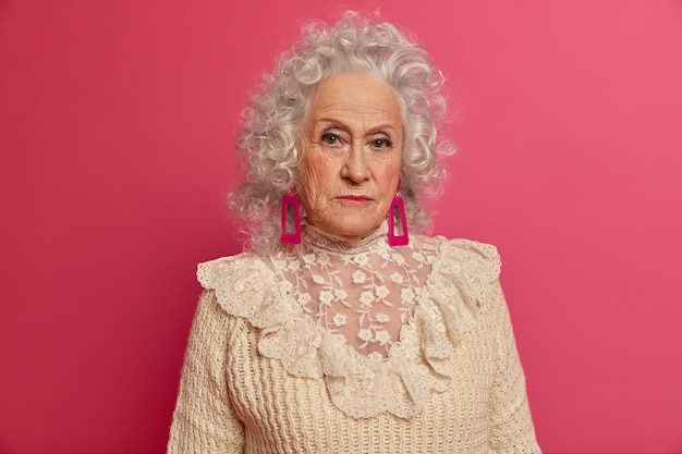 Close up on elegant elderly woman wearing stylish clothes isolated