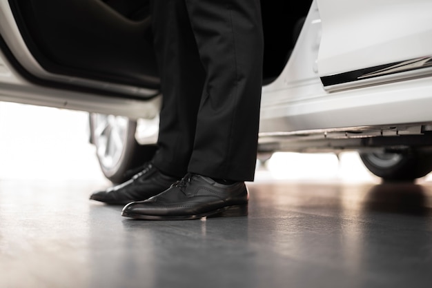 Free photo close-up elegant man getting out of car