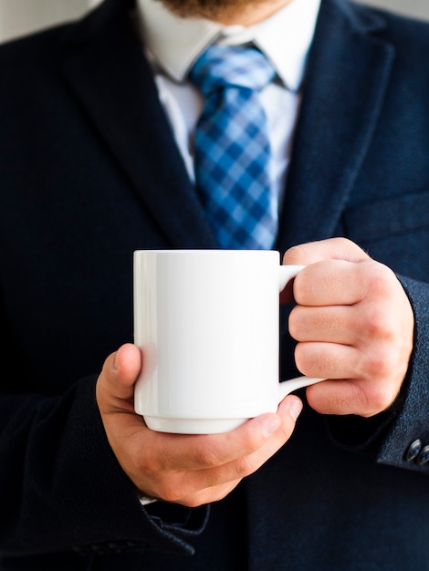 Close-up elegant man holding up mug