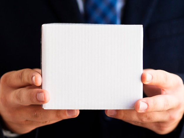 Close-up elegant man holding up small box